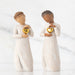 Two figurines holding gold hearts against a white background