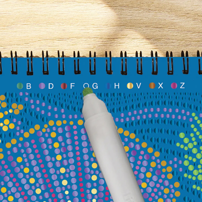 Colorful dot pattern on a blue notebook with a pen on a wooden surface