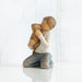 figure of kneeling boy in cream shirt and blue jeans, holding golden dog in his arms