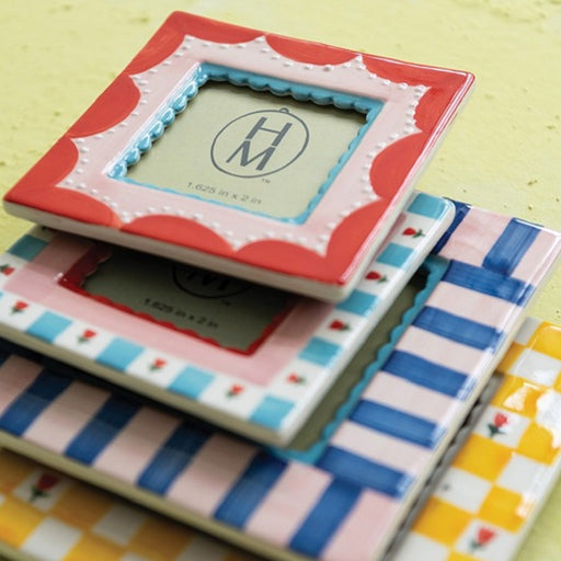 Stack of colorful ceramic tiles with decorative patterns on a yellow surface