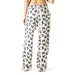 White pajama pants with black bow pattern worn by a person on a white background