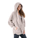Woman wearing a beige hooded poncho on a white background