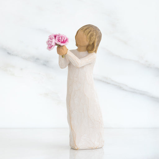 Statue of a person holding pink flowers against a white background