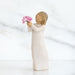 Statue of a person holding pink flowers against a white background