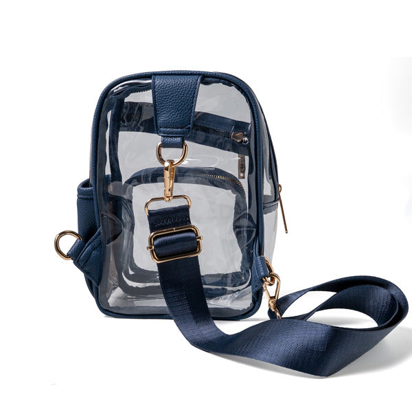Clear bag with navy straps and gold hardware on a white background