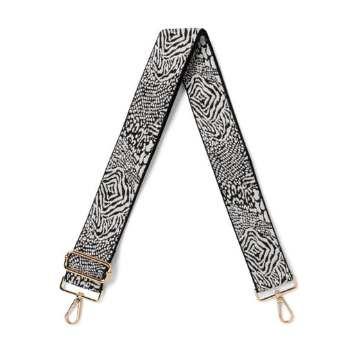 Black and white patterned bag strap with gold hardware on a white background