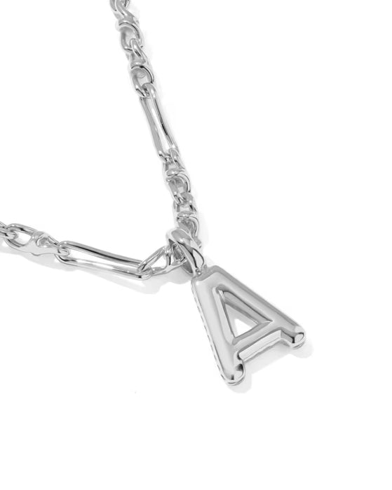 A close-up of a silver necklace featuring a polished triangular letter 'A' pendant and a matching silver chain on a white background.