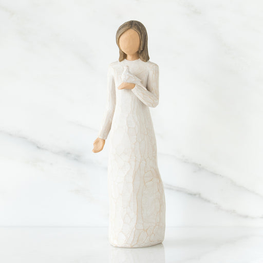 White ceramic figurine of a woman in a long dress on a white background