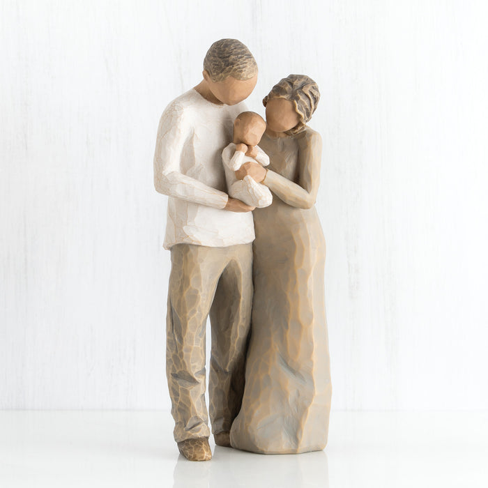 Statue of a couple holding a baby on a white background