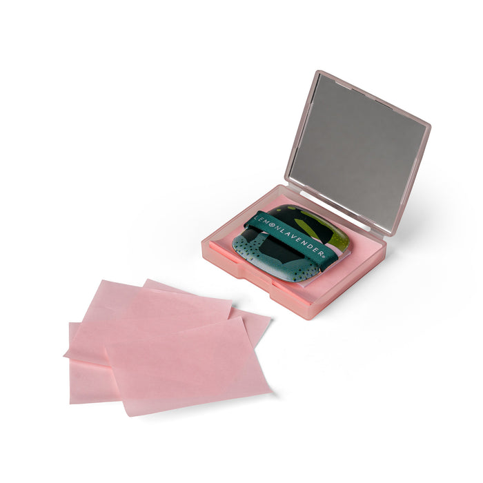 Compact mirror with pink case and three pink pads on a white background