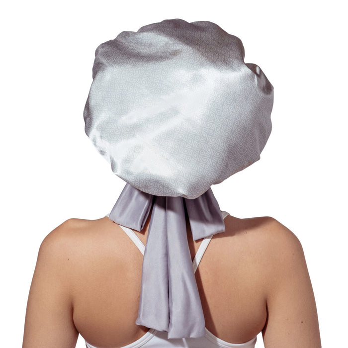 Person wearing a large white satin head wrap on a white background