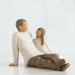 Wooden figurine of a man and woman sitting together on a white background