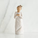 Ceramic angel figurine holding a heart on a white background
