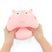 A pink Peppa Pig-shaped squishy stress toy being squeezed by two hands against a plain white background.