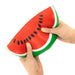Hand holding a watermelon-shaped stress ball against a white background