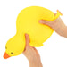Yellow rubber duck being held by a hand on a white background