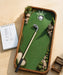 Golf-themed desk organizer with miniature golf course, club, and notepad on a wooden surface.