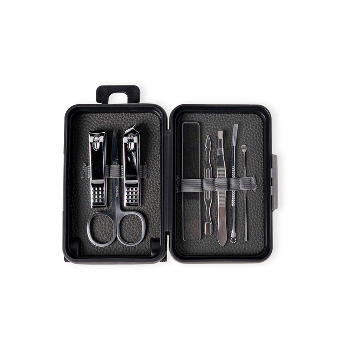 Manicure set with tools in an open black case on a white background