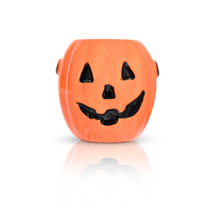 Orange pumpkin-shaped container with a black face on a white background
