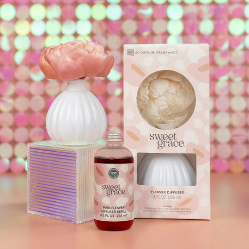 Sweet Grace flower diffuser set with packaging against a colorful bokeh background