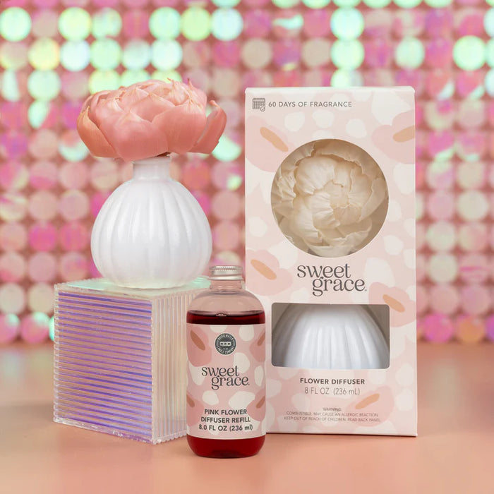 Sweet Grace flower diffuser set with packaging against a colorful bokeh background