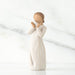 White ceramic figurine of a woman holding a heart-shaped object on a white background