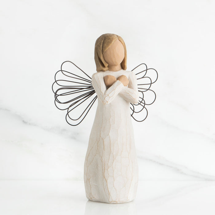 White angel figurine with wire wings on a white background