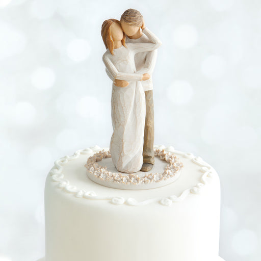 Wedding cake topper with a couple embracing on a white background