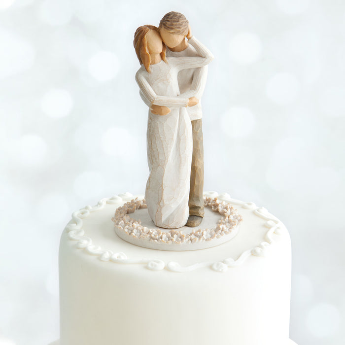 Wedding cake topper with a couple embracing on a white background