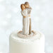 Wedding cake topper with a couple embracing on a white background