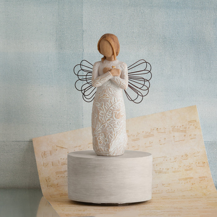 Ceramic angel figurine with open wings on a textured surface