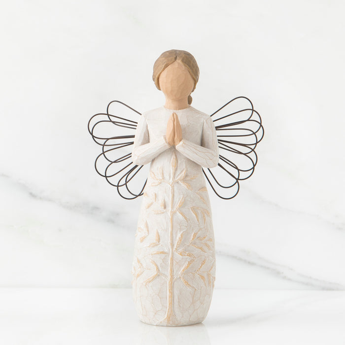 Standing angel in cream dress with wire wings, with hands in prayer position; tree carving on angel's dress