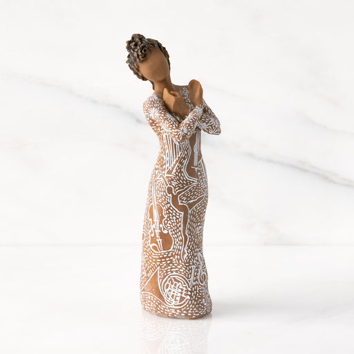 Ceramic figurine of a woman with intricate patterns on a white background