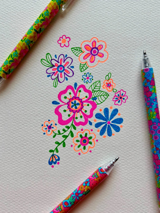 Colorful floral drawings on paper with floral-patterned pens.
