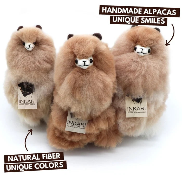 Three fluffy alpaca plush toys in natural fiber, shown against a white background with promotional text overlays. The brand name INKARI is visible on the tags.