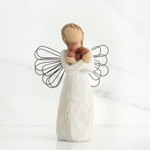 Angel figurine holding a heart-shaped object on a white background