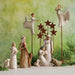 Nativity scene with figures and decorative elements on a green background