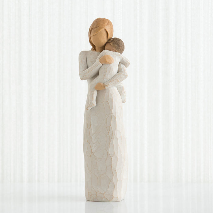 Standing figure in cream dress holding toddler in cream onesie