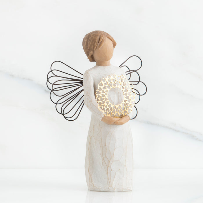 Standing angel in cream dress and wire wings, holding thin, pierced-metal, gold-leafed wreath of hearts