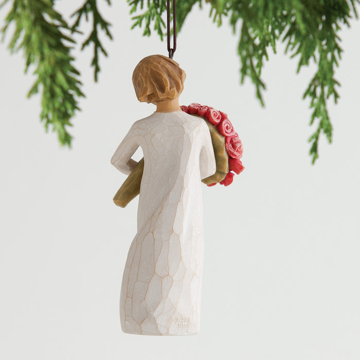Angel ornament holding flowers hanging from a tree