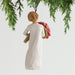 Angel ornament holding flowers hanging from a tree