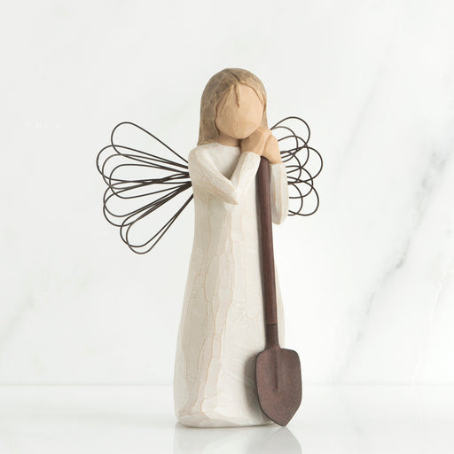 Decorative angel figurine with a shovel on a white background