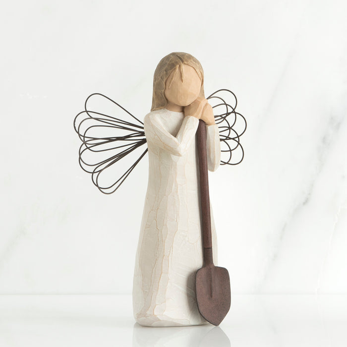 Decorative angel figurine with a shovel on a white background