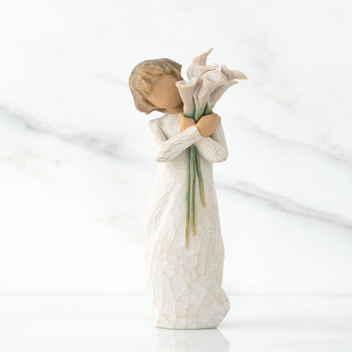 Decorative figurine of a woman holding flowers on a white background