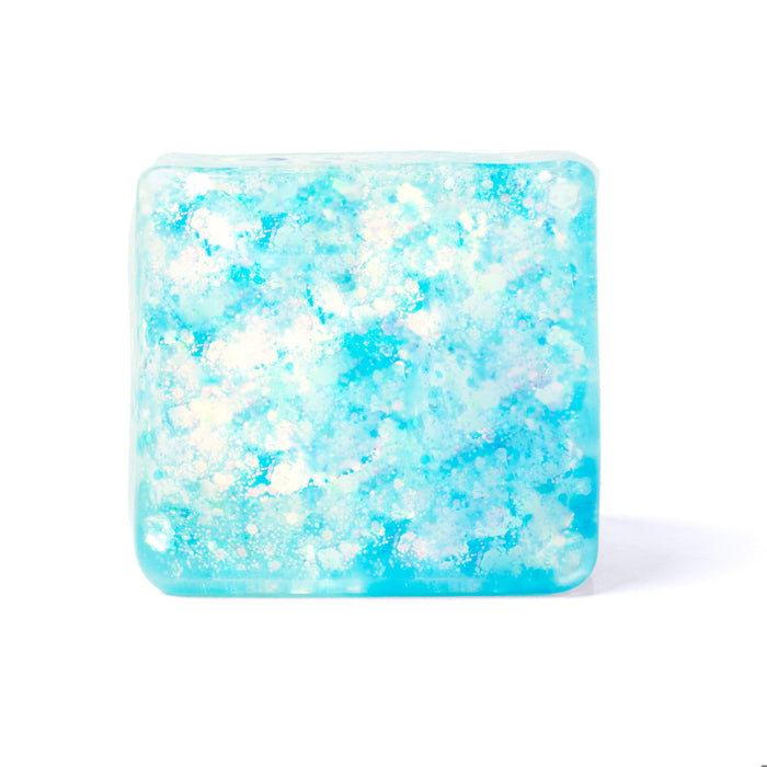 A square translucent bath bomb or soap bar with a textured, bubbly pattern in shades of light blue, cyan, and white, set against a plain white background.