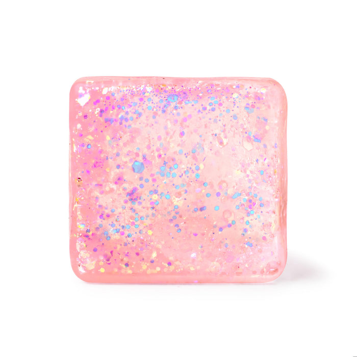 A square pink resin plaque or coaster with rounded corners, filled with iridescent glitter in shades of blue, purple, and gold, shown on a clean white background.