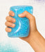 Hand holding a blue glittery jar against a white background