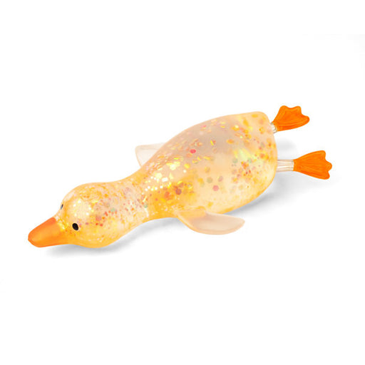 A translucent yellow duck-shaped toy filled with glitter, featuring a bright orange beak, black eyes, and orange webbed feet, shown on a plain white background.