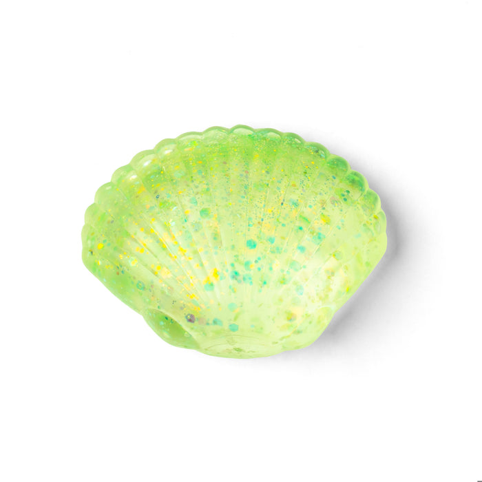 A translucent light green seashell-shaped object with scattered green and yellow glitter, shown on a plain white background.