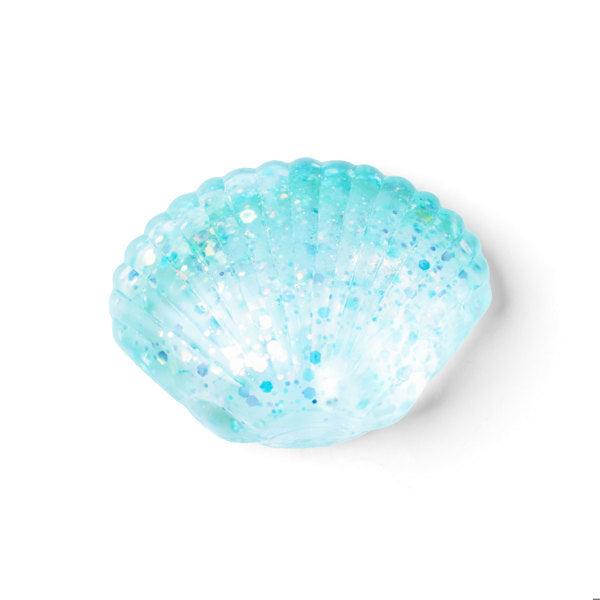 A light blue glittery seashell-shaped container or bowl, photographed on a clean white background.